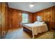 Cozy bedroom featuring wood paneling and natural light from a window at 1301 Old Farm Rd, Charlotte, NC 28226