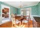 Cozy dining room with hardwood floors, decorative wallpaper, and views into the living room and kitchen at 1301 Old Farm Rd, Charlotte, NC 28226