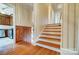 Hallway with a wooden staircase and view into the kitchen area at 1301 Old Farm Rd, Charlotte, NC 28226