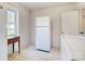 Functional laundry area featuring ample space with a refrigerator and tile floors at 1301 Old Farm Rd, Charlotte, NC 28226