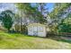 Charming white outbuilding with a weathered door and windows set within a lush green backyard at 1301 Old Farm Rd, Charlotte, NC 28226