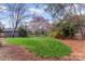 Lush backyard featuring mature trees, vibrant green lawn, and a charming landscape design at 1416 Woodland Dr, Charlotte, NC 28205
