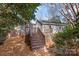 Backyard with a wood deck, stairs to the yard, and mature trees at 1416 Woodland Dr, Charlotte, NC 28205
