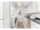 Bright laundry room with white washer, dryer, cabinets, and a window for natural light at 1416 Woodland Dr, Charlotte, NC 28205