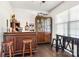 Home wet bar featuring wood cabinetry, wine storage, seating and a large window at 14815 Superior St, Charlotte, NC 28273