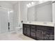Bathroom featuring double sinks, dark vanity, and glass-enclosed shower at 14815 Superior St, Charlotte, NC 28273