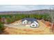 This aerial showcases a white single-story home with a red door, nestled in a serene, tree-lined landscape at 150 Belk Estate Dr, Mooresville, NC 28115