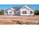 The exterior features white siding, dark shutters, and a vibrant red door, perfectly framed against a clear, blue sky at 150 Belk Estate Dr, Mooresville, NC 28115