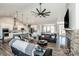 Open living room with stone fireplace, ceiling fan, and a seamless flow into a modern kitchen at 150 Belk Estate Dr, Mooresville, NC 28115