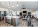 Open-concept living space features a modern kitchen with a large island and a cozy living area with a stone fireplace at 150 Belk Estate Dr, Mooresville, NC 28115