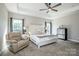 Comfortable main bedroom features a cozy reading chair, a ceiling fan, and soft natural lighting at 150 Belk Estate Dr, Mooresville, NC 28115