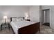 The carpeted bedroom features a queen-size bed, a glass side table, and ample natural light at 15035 Batteliere Dr, Charlotte, NC 28278