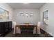 Bright dining room featuring a modern table, hardwood floors, and natural light from three windows at 15035 Batteliere Dr, Charlotte, NC 28278