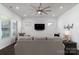 Bright living room featuring a ceiling fan, plush gray sofa, and mounted TV at 15035 Batteliere Dr, Charlotte, NC 28278