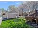 Spacious backyard with lush green grass, a detached garage, and blossoming trees at 16504 Knox Run Rd, Huntersville, NC 28078