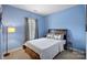 Comfortable bedroom with a queen bed, blue walls, and ample natural light at 16504 Knox Run Rd, Huntersville, NC 28078