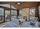 Inviting sunroom with a stone fireplace, comfortable seating, and scenic outdoor views at 16504 Knox Run Rd, Huntersville, NC 28078
