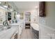 Bathroom featuring double sink vanity, large mirror, soaking tub and door to bedroom at 1703 Luther St, Charlotte, NC 28204