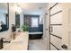 Modern bathroom featuring double sinks, vanity, marble countertops, soaking tub and glass shower at 1703 Luther St, Charlotte, NC 28204