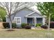 Charming blue house with manicured landscaping, a cozy front porch, and a well-maintained lawn at 1703 Luther St, Charlotte, NC 28204