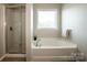 Bright bathroom featuring a soaking tub and a separate glass enclosed shower at 19915 Lamp Lighters Way, Cornelius, NC 28031