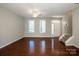 Spacious living area with hardwood floors, bright windows, and access to the stairs at 19915 Lamp Lighters Way, Cornelius, NC 28031