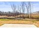 View of a backyard featuring a walking bridge, trees and dry vegetation at 2131 Belterra Dr, Charlotte, NC 28216
