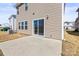 View of a home's backyard showcasing vinyl siding, sliding glass doors and a concrete patio at 2131 Belterra Dr, Charlotte, NC 28216
