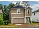 Charming home featuring neutral siding, a dark roof, attached garage, and well-manicured landscaping at 2131 Belterra Dr, Charlotte, NC 28216