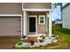 Inviting front door with stone-accented flower beds, covered entry way, and covered area for deliveries at 2131 Belterra Dr, Charlotte, NC 28216