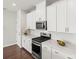 Bright kitchen features white cabinets, stainless steel appliances, white countertops and hardwood flooring at 2131 Belterra Dr, Charlotte, NC 28216