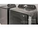 Modern laundry room with front loading washer and dryer in neutral colors and digital display at 2131 Belterra Dr, Charlotte, NC 28216