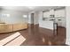 Open-concept living room featuring hardwood floors, and a kitchen in the background at 2131 Belterra Dr, Charlotte, NC 28216