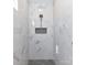 Modern shower with white marble walls, a black pebble floor, and a recessed shower caddy at 2328 Kingsburry Rd, York, SC 29745