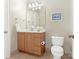 Cozy bathroom featuring a wooden vanity, framed mirror, and ceramic tile flooring at 261 Crownsgate Ct, Charlotte, NC 28207