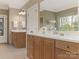 Bathroom featuring double vanity sinks with bright white counter tops and wooden cabinets at 261 Crownsgate Ct, Charlotte, NC 28207