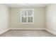 Well-lit bedroom with neutral walls, carpeting, and large window offers a serene and comfortable space at 261 Crownsgate Ct, Charlotte, NC 28207