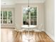 Bright dining area with hardwood floors, modern chandelier, and large windows overlooking lush greenery at 261 Crownsgate Ct, Charlotte, NC 28207