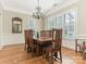 Bright dining room with hardwood floors, a chandelier, and large windows with plantation shutters at 261 Crownsgate Ct, Charlotte, NC 28207