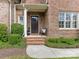 Inviting front entrance with brick steps, a covered porch, and professionally landscaped greenery at 261 Crownsgate Ct, Charlotte, NC 28207