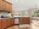 Kitchen with stainless steel appliances, wood cabinets and view to light filled dining area at 261 Crownsgate Ct, Charlotte, NC 28207