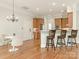 Open kitchen with breakfast bar, stainless steel appliances, and dining area with modern chandelier at 261 Crownsgate Ct, Charlotte, NC 28207