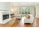 Inviting living room with a fireplace, hardwood floors, large windows, and neutral decor at 261 Crownsgate Ct, Charlotte, NC 28207