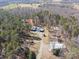 An elevated view of a country estate surrounded by dense trees, with outbuildings and a winding driveway leading to the home at 265 River Run Rd, Statesville, NC 28625
