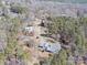 A high-angle view of a rural property, featuring a home with outbuildings and a long driveway through a wooded area at 265 River Run Rd, Statesville, NC 28625