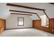 Finished attic space with exposed wooden beams, wooden wainscoting, and a light carpet at 265 River Run Rd, Statesville, NC 28625