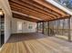 Covered wooden back deck with an exposed-beam ceiling and views of the surrounding yard at 265 River Run Rd, Statesville, NC 28625