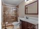 Bathroom featuring a tiled shower with glass door and a modern vanity with dark wood cabinetry at 265 River Run Rd, Statesville, NC 28625