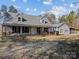 Charming home features a metal roof, inviting front porch with swing, and well-maintained landscaping at 265 River Run Rd, Statesville, NC 28625