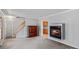 Living room with wood staircase and fireplace, flowing into an adjacent room at 265 River Run Rd, Statesville, NC 28625